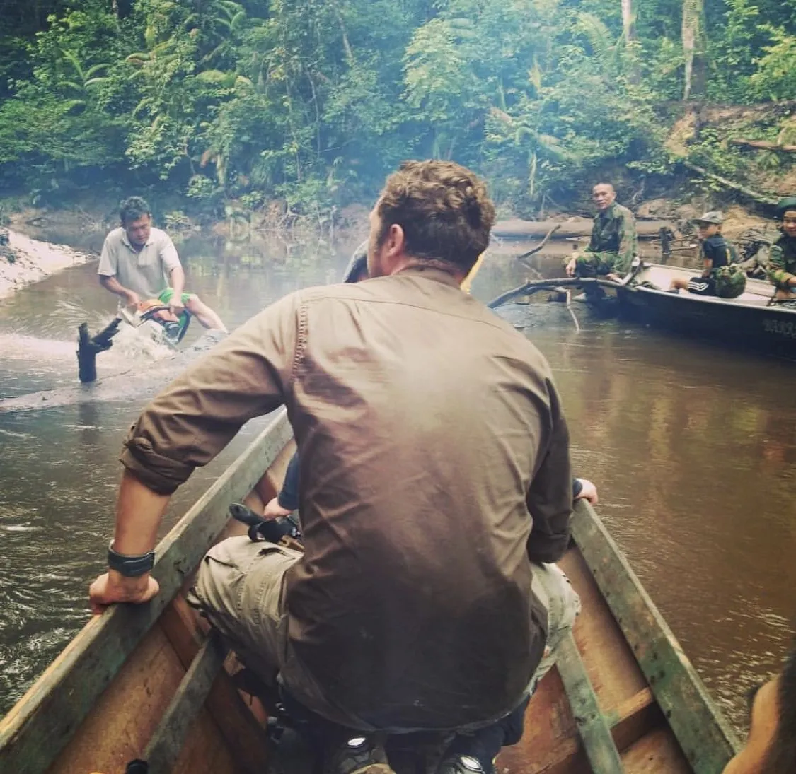 Tim standing barefoot on red earth watching elephants in Kenya