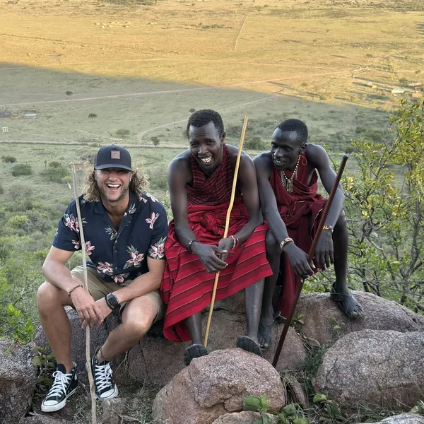 Tim laughing with two Maasai friends on a hillside in Kenya